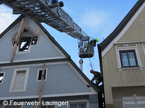 Dachsicherungsarbeiten durch einen abgeseilten Feuerwehrkollegen